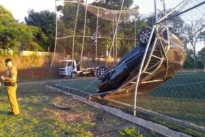 Carro fica pendurado em grade de campo de futebol no PR