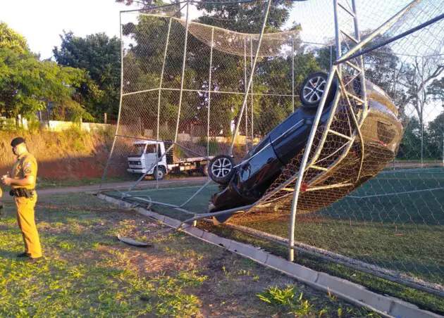 Carro fica pendurado em grade de campo de futebol no PR